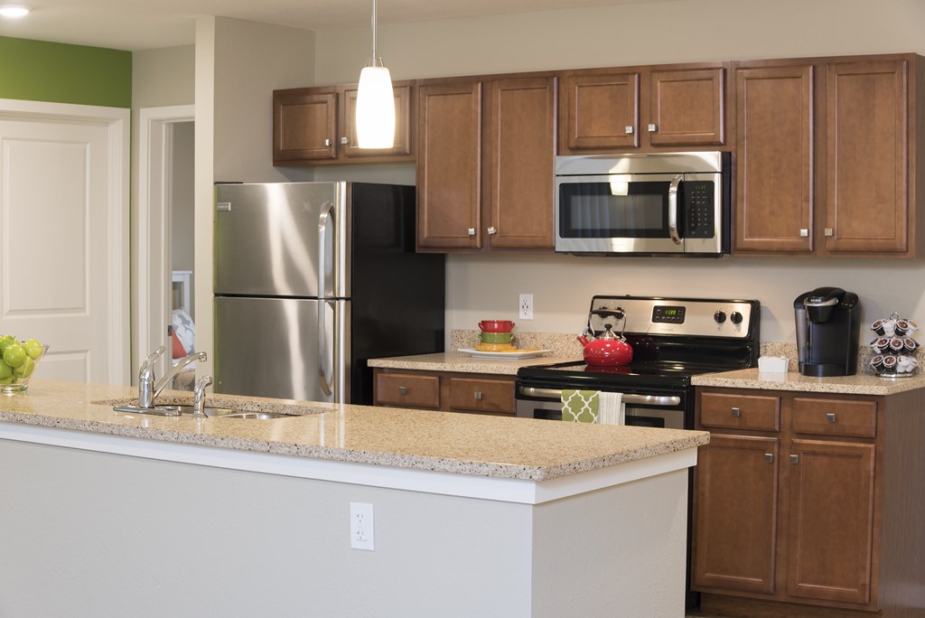 A kitchen with a stove top oven and a microwave above it.
