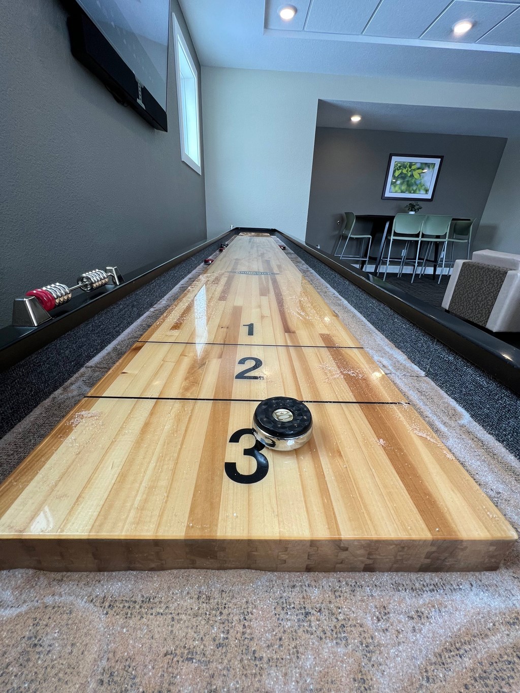 A wooden bowling lane with numbers 1, 2, and 3 on it.