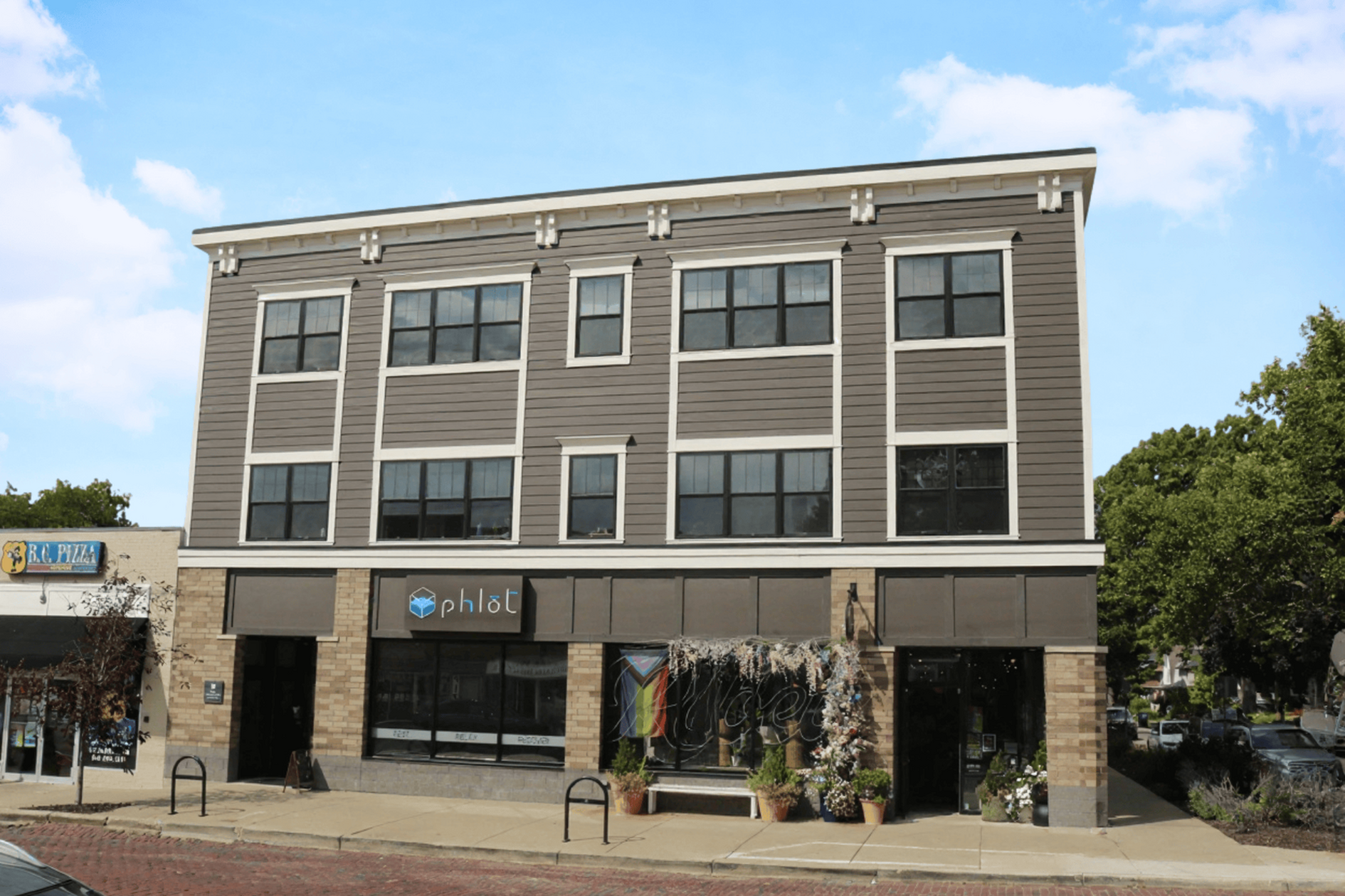 A grey building with a store front on the ground floor.