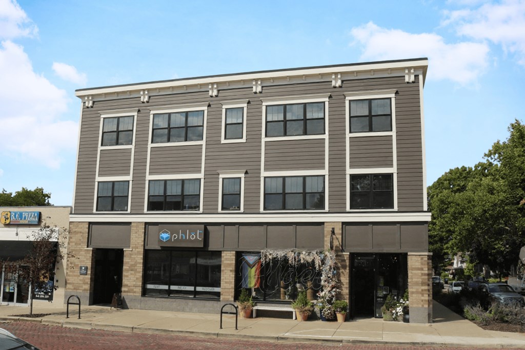 A grey building with a store front on the ground floor.