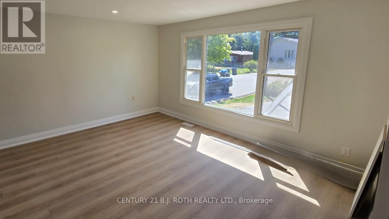 A room with a large window and wooden flooring.