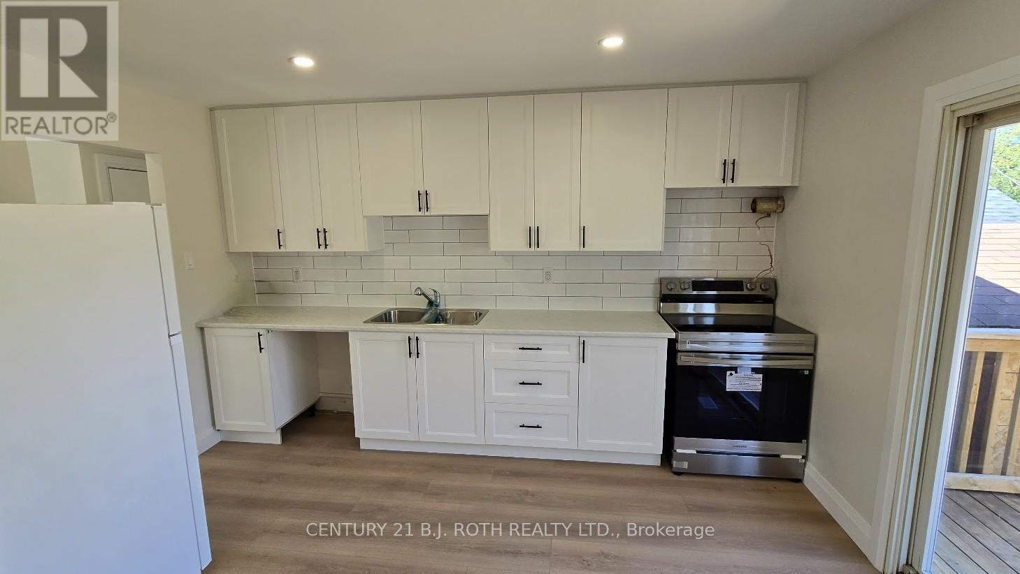 A kitchen with white cabinets and a sink.