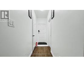 A hallway with a door and a sign on the wall.