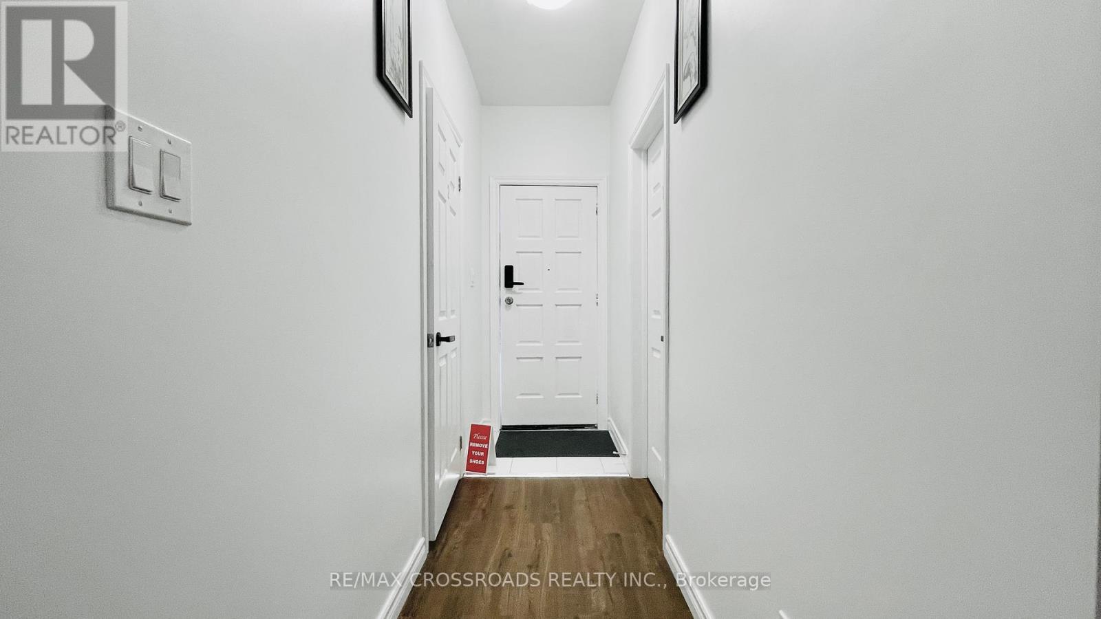 A hallway with a door and a sign on the wall.