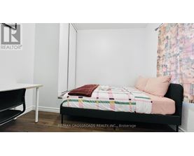 A bedroom with a bed, a table, and a chair.