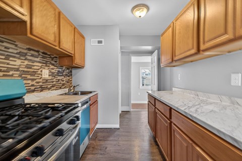 A kitchen with a blue stove top oven and wooden cabinets.
