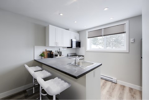 A kitchen with a counter and bar stools.