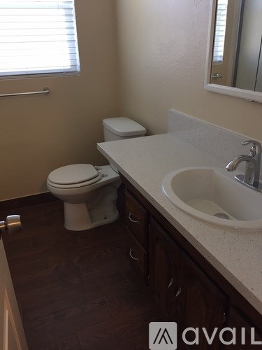 A bathroom with a toilet, sink, and mirror.