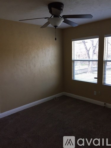 A room with a ceiling fan and a window.