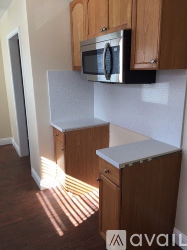 A kitchen with wooden cabinets and a microwave above the counter.