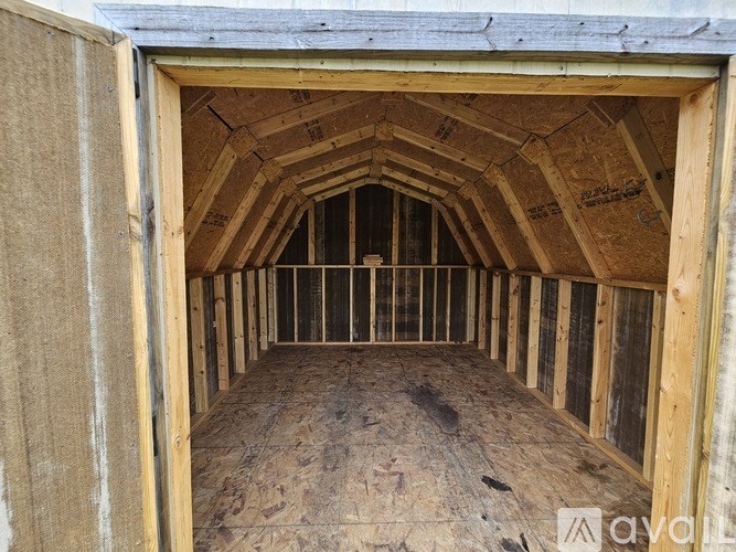 A view of an attic with wooden beams and insulation.