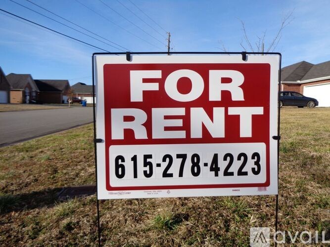 A red and white For Rent sign with a phone number on it.