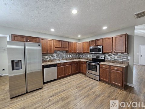 A kitchen with wooden cabinets and stainless steel appliances.