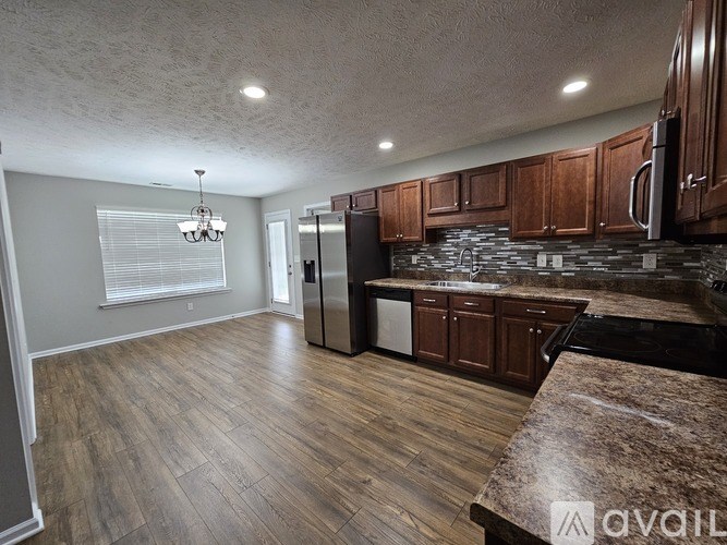 A kitchen with wooden cabinets and a black dishwasher.