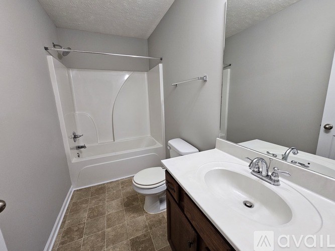 A bathroom with a toilet, sink, and shower.
