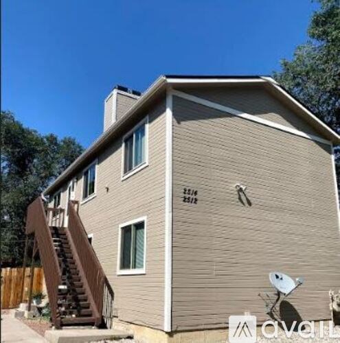 A house with a brown siding and a satellite dish on the roof.