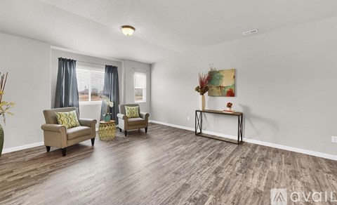 A living room with two chairs and a table.