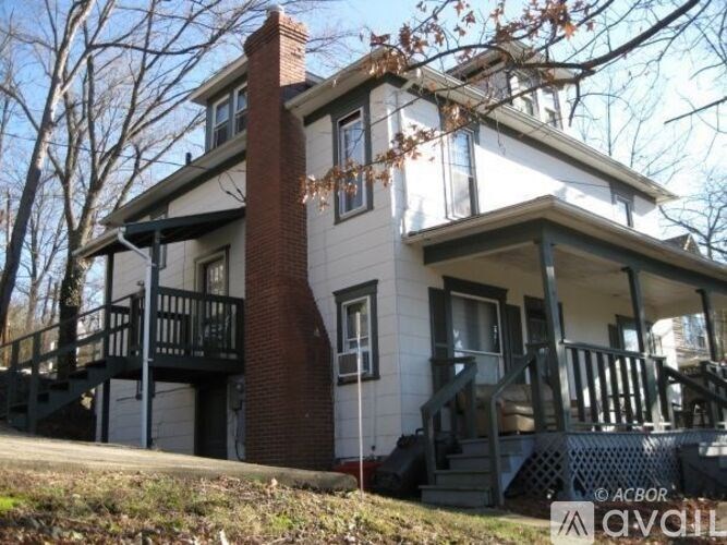 A two-story house with a balcony on the second floor.