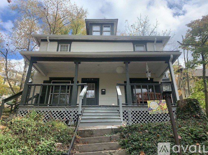 A house with a front porch and stairs leading up to the entrance.