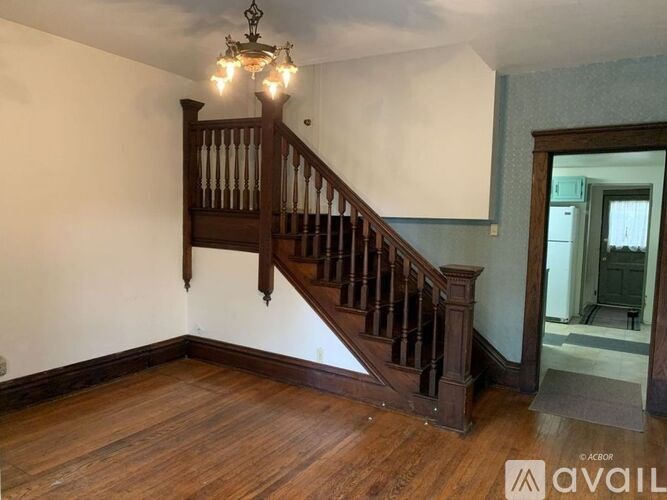 A wooden staircase with a chandelier above it.