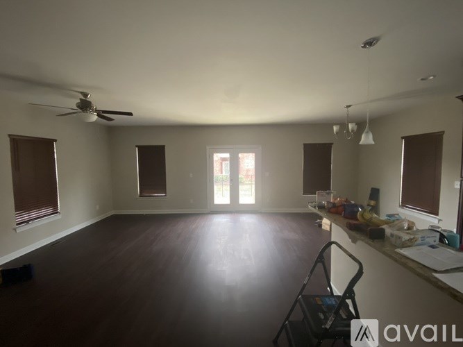 A room with a fan and a vacuum cleaner on the floor.