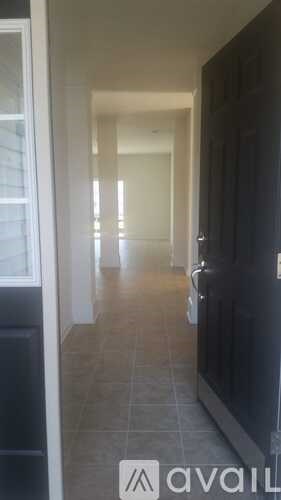 A hallway with a tiled floor and a door on the right.