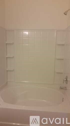 A white bathroom with a bathtub and a towel rack.