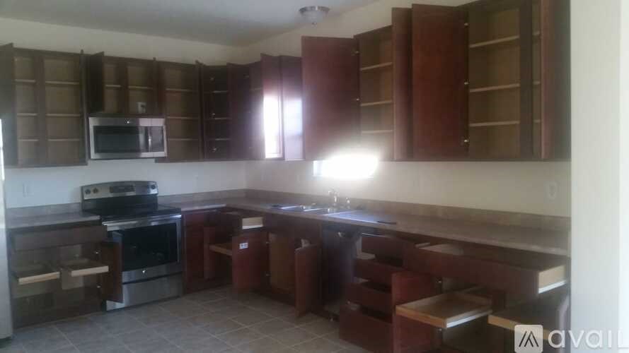 A kitchen with brown cabinets and a black stove top oven.