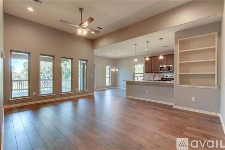 A spacious living room with hardwood floors and a ceiling fan.