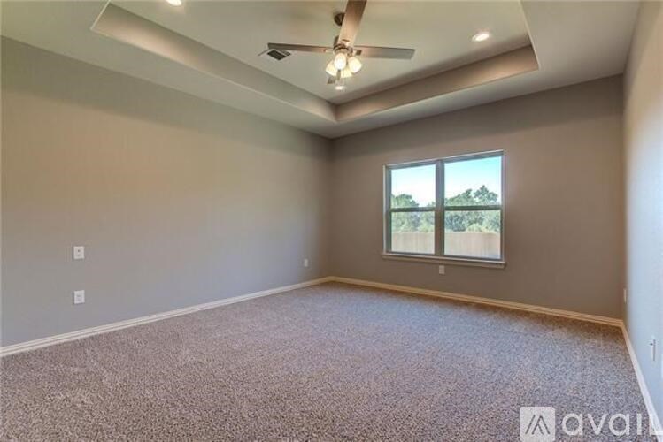 A room with a ceiling fan and a window overlooking a view.