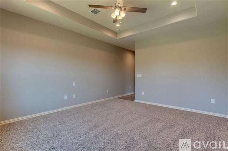 A spacious room with a ceiling fan and carpeted floor.