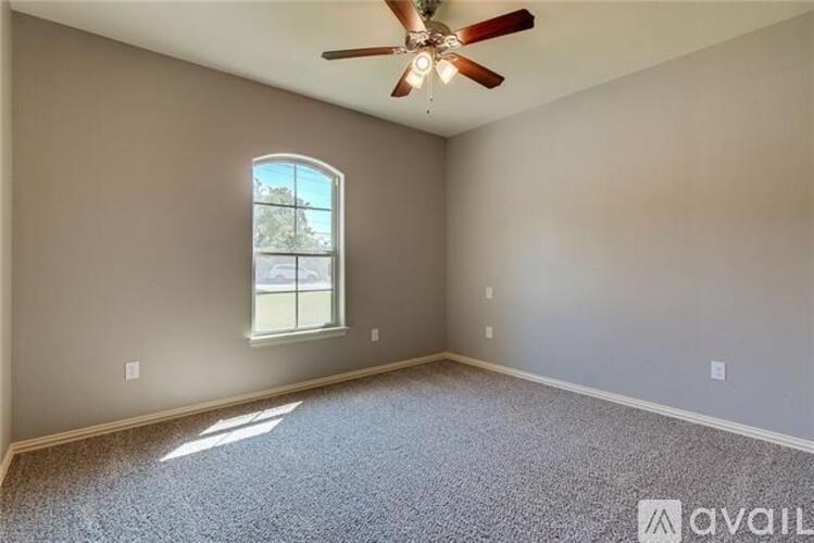 A room with a ceiling fan and a window.