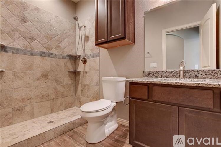 A bathroom with a white toilet and brown cabinets.