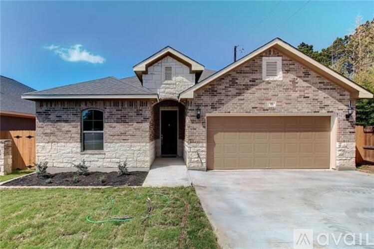 A house with a garage and a driveway in front.