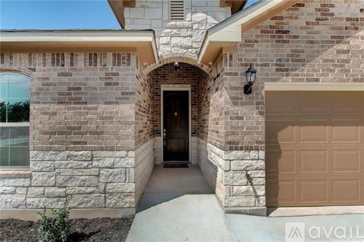 A house with a brown garage door and a stone archway.