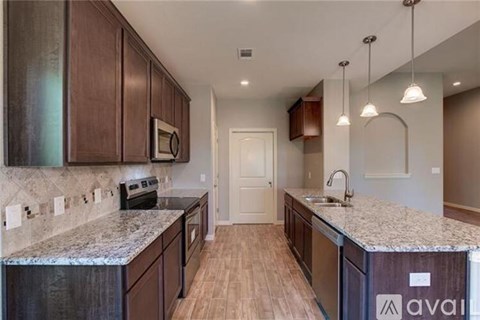 A kitchen with wooden cabinets and granite countertops.