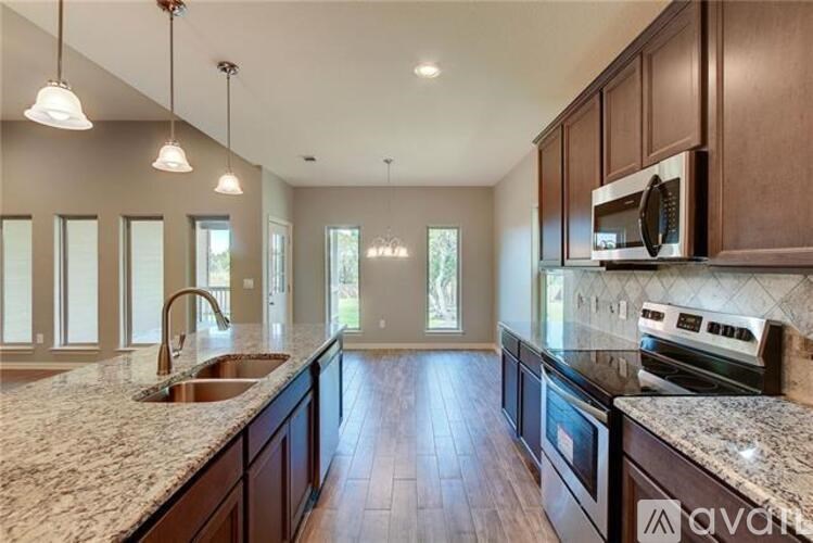 A kitchen with dark wood cabinets and granite countertops.
