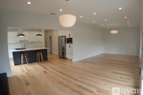 A kitchen with wooden floors and a refrigerator.
