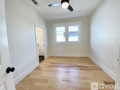 A room with a wooden floor and a ceiling fan.