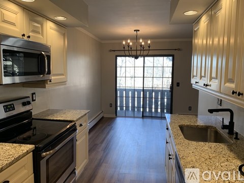 A kitchen with wooden cabinets and granite countertops.