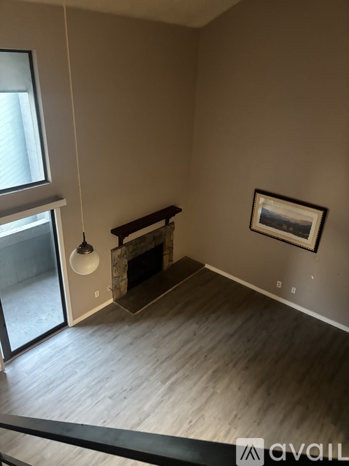 A living room with a fireplace and a painting on the wall.