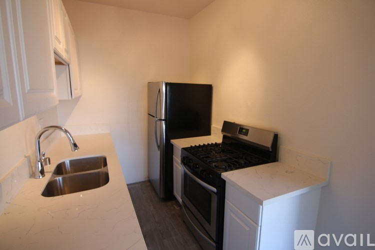 A kitchen with a sink, stove, and refrigerator.