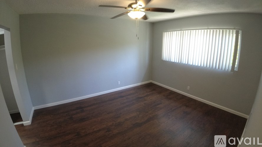 A room with wooden flooring and a ceiling fan.