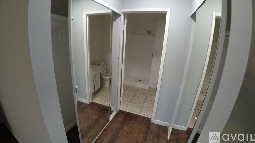 A bathroom with a toilet and sink is visible through a doorway.