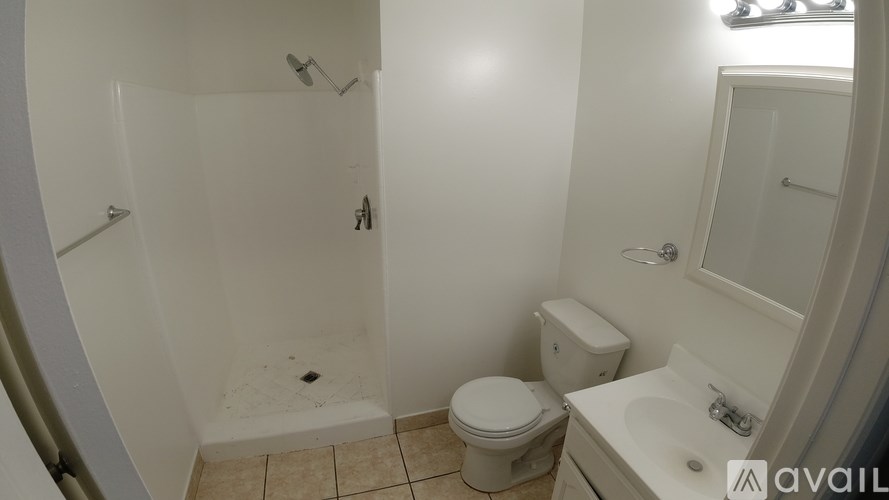 A bathroom with a toilet, sink, and shower.