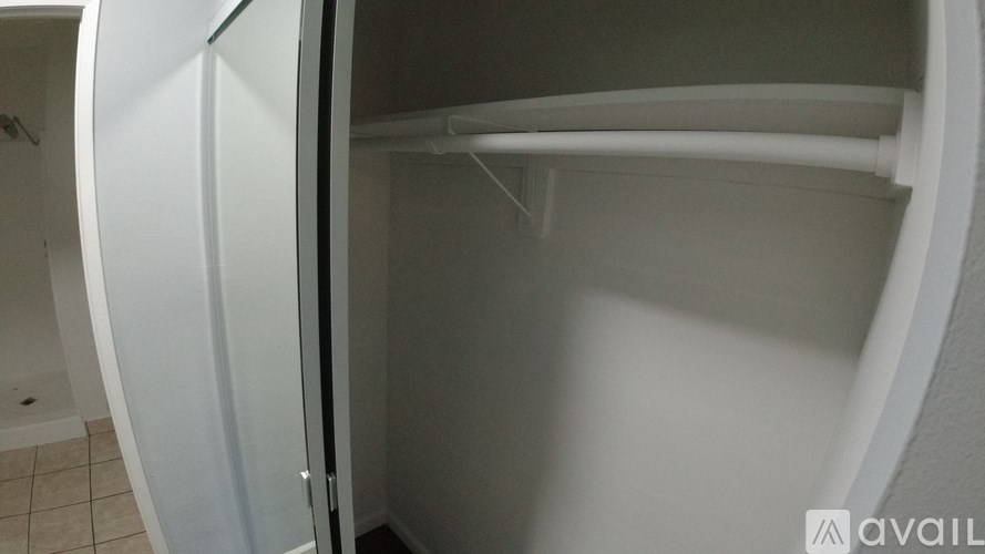 A white circular room with a door open to a bathroom.