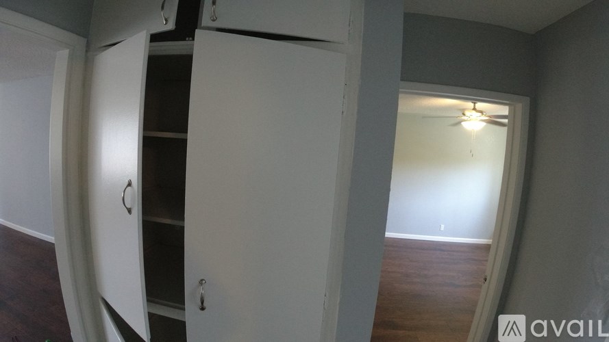 A room with a white door and a ceiling fan.