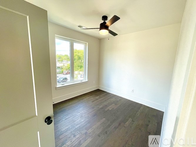 A room with a ceiling fan and a door.