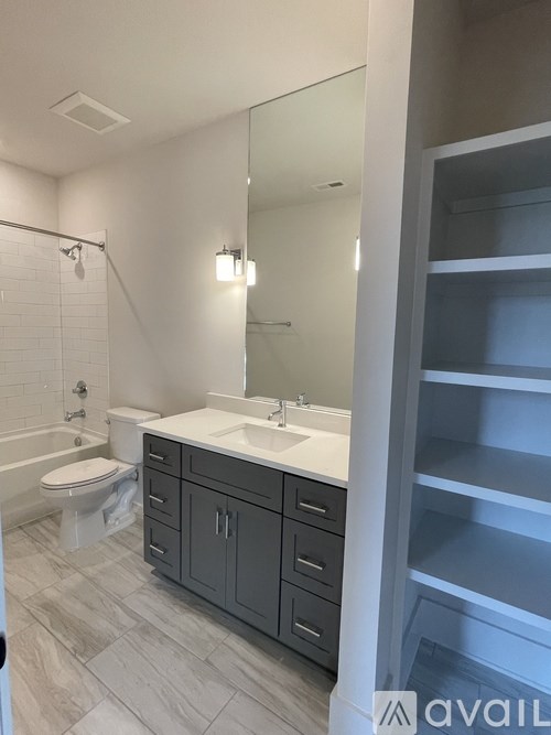 A bathroom with a toilet, sink, and a mirror.