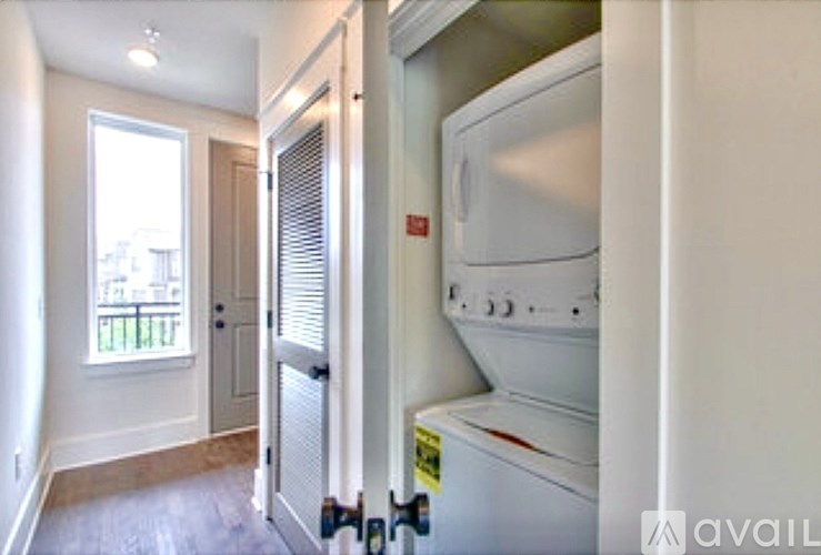 A white dryer is in a small room with a window.